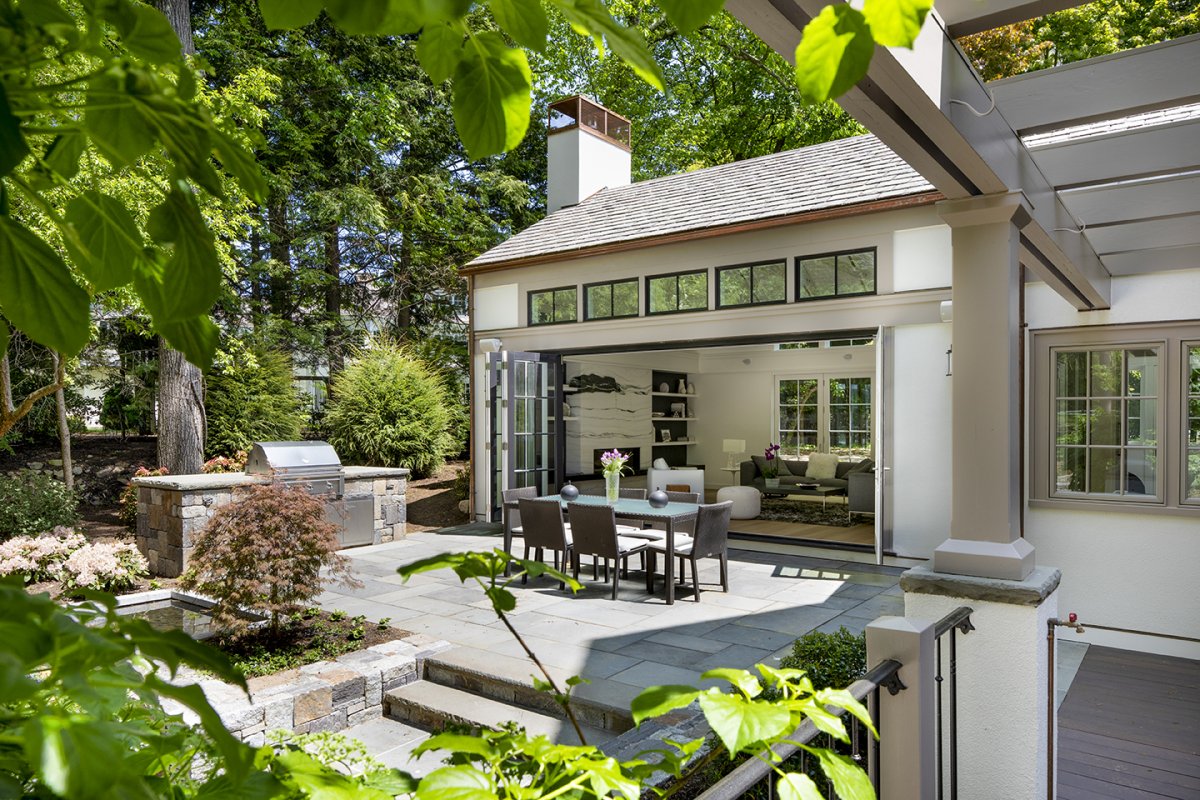 outdoor view of house with bbq wall and open doors© Jacob Lilley Architects Wellesley, MA